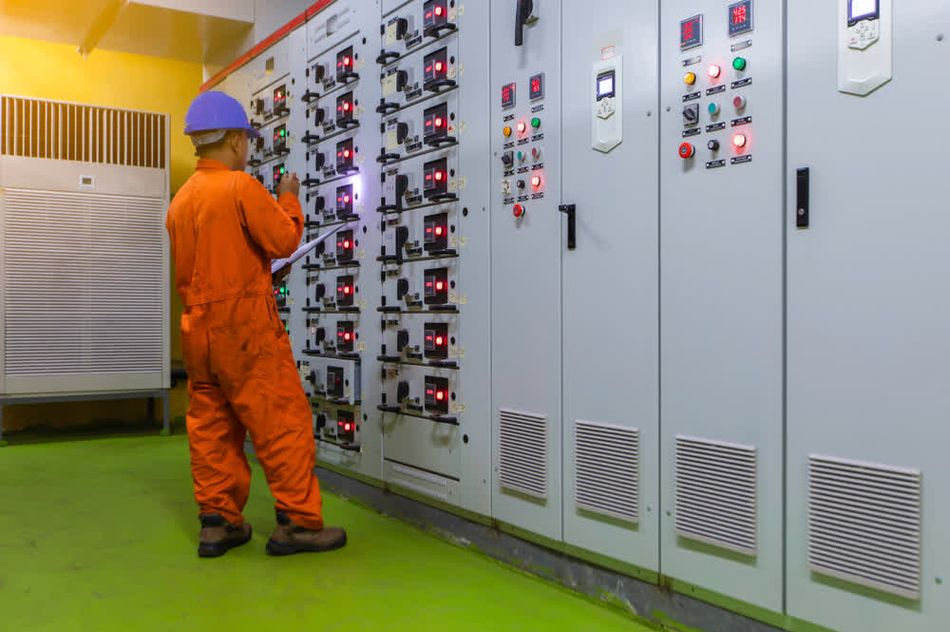 An engineer wearing protective equipment while monitoring a MCC