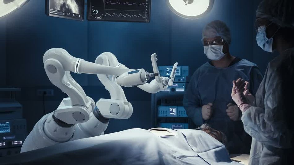 A group of surgeons observe robotic arms during surgery