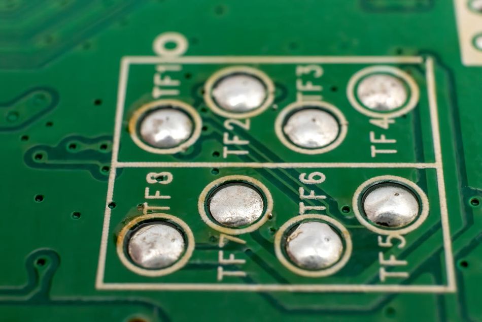 Close-up of solder balls on a PCB, showing BGA pad layout and reflowed joints used in high-density component packaging for LCD or consumer electronics."