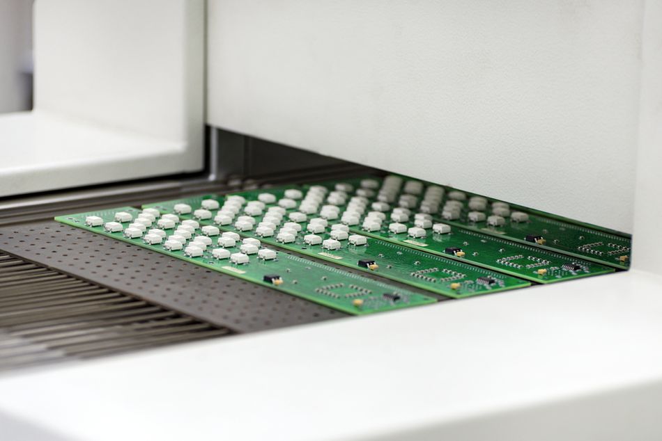 Printed circuit boards coming out of a reflow oven
