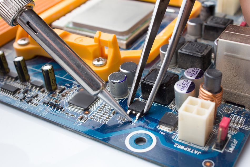 MOSFET Transistor Key being Soldered Out of the Computer Board