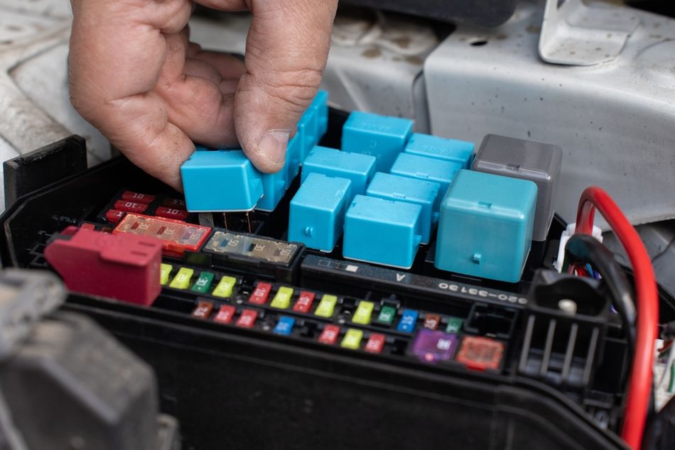 Automotive relays being installed/replaced in a car panel