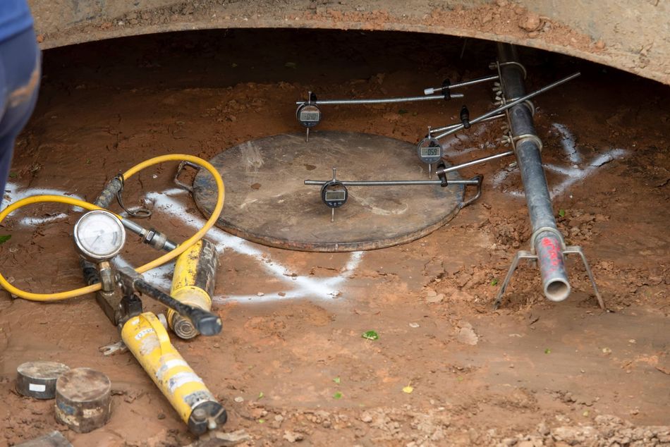 Geotechnical technician using gauges to perform California Bearing Ratio (CBR) test 