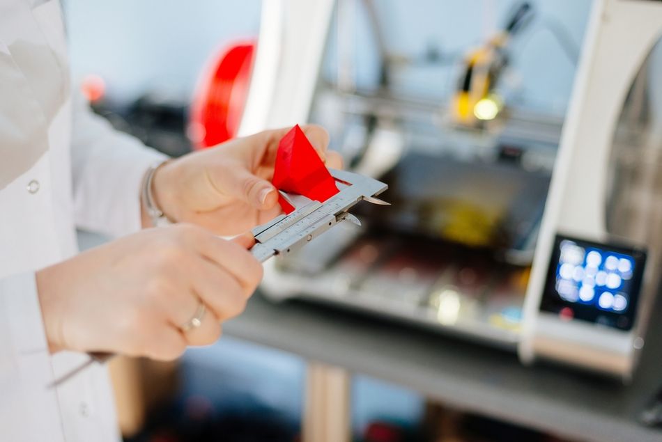 Engineer using calipers to check the dimensions of a part