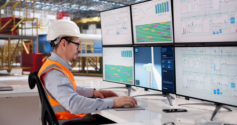 Engineer uses CAD software on multiple screens