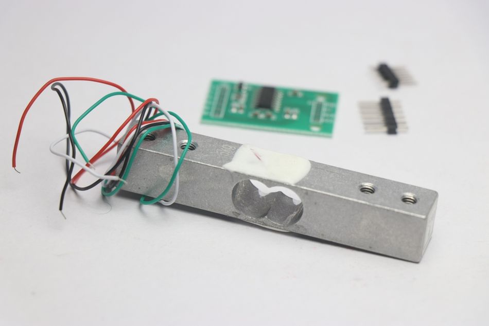 Load Cell Module with Amplifier in the Background with Unsoldered Pins