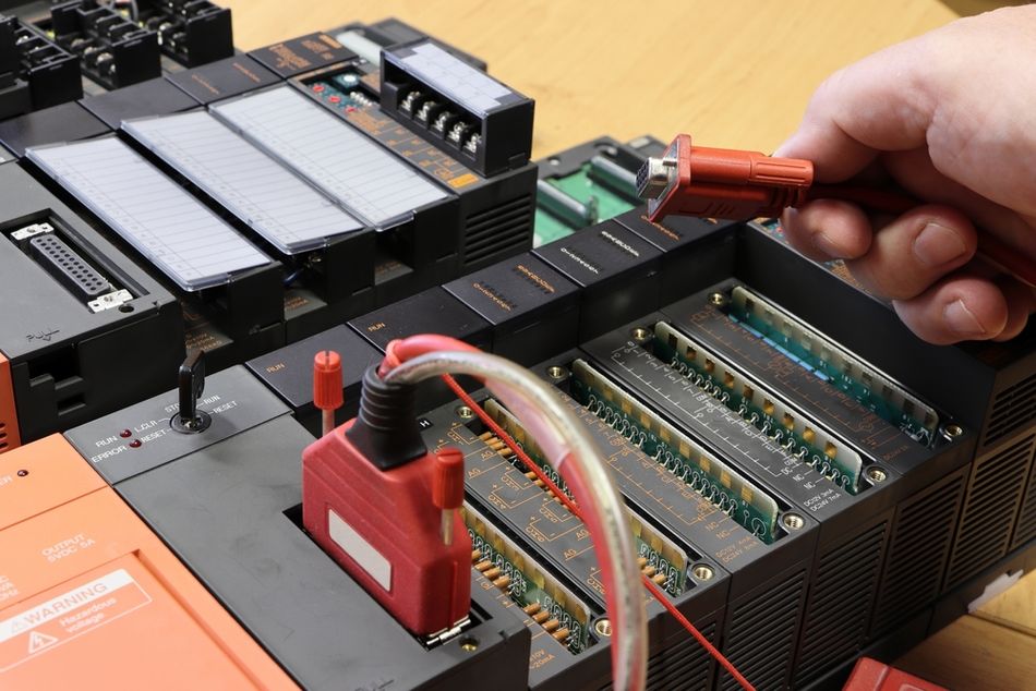 Engineer holding Communication Cable to the PLC