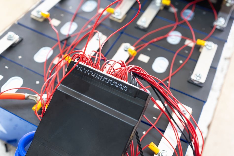 Technician Connects BMS to LiFePO4 Battery Pack for Off-Grid Solar System