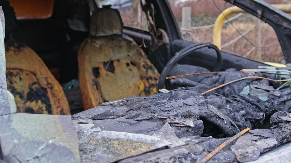 Burnt Electric Car Wreck with Melted Interior and Tires Caused by Battery Fire
