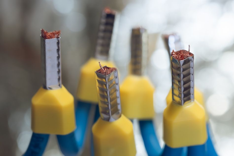 Macro view of multiple electrical cables with sections of insulation removed, exposing the conductors for termination, connection, or installation in electrical equipment.